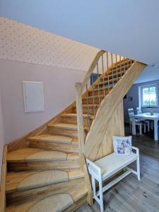 a staircase in a house with a white chair at Landlust in Leutersdorf