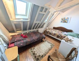 - une chambre mansardée avec 2 lits et une table dans l'établissement La bi-coque du Courtgain, charmante et atypique, à Saint-Valery-sur-Somme