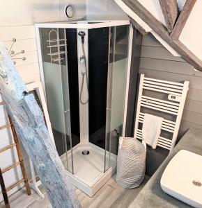 une douche avec une porte vitrée dans une salle de bain dans l'établissement La bi-coque du Courtgain, charmante et atypique, à Saint-Valery-sur-Somme 18 autres photos