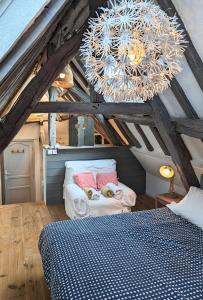 une chambre avec un lit et un lustre dans l'établissement La bi-coque du Courtgain, charmante et atypique, à Saint-Valery-sur-Somme