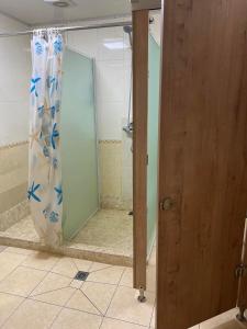 a shower stall with a shower curtain in a bathroom at Rest Easy Inn in Ulaanbaatar