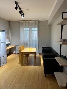 a kitchen and living room with a table and a couch at Rest Easy Inn in Ulaanbaatar