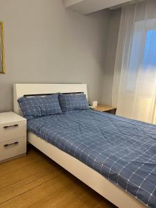 a bedroom with a bed with a blue comforter at Rest Easy Inn in Ulaanbaatar