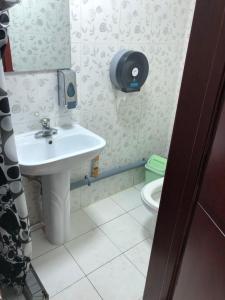 a bathroom with a sink and a toilet at Rest Easy Inn in Ulaanbaatar
