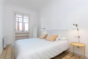 a white bedroom with a white bed and a window at eg42b - Modernista apartamento en el centro de Barcelona in Barcelona