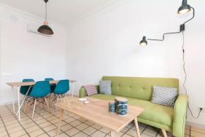 a living room with a green couch and a table at eg42b - Modernista apartamento en el centro de Barcelona in Barcelona