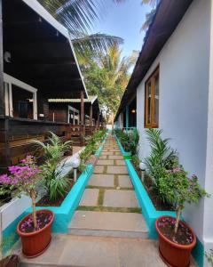 a pathway leading to a house with potted plants at Sand Tent Beach House PALOLEM in Canacona
