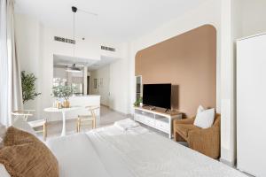 a bedroom with a bed and a tv and a table at Silkhaus Sea View studio in Marina Rise Tower in Abu Dhabi