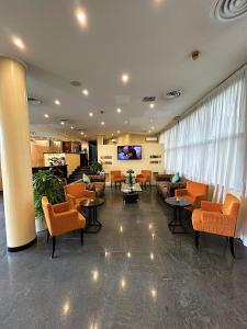 eine Lobby mit Sofas, Tischen und einem TV in der Unterkunft iH Hotels Milano Blu Visconti in Trezzano sul Naviglio