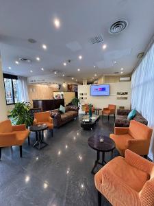 eine Lobby mit Sofas, Tischen und einem TV in der Unterkunft iH Hotels Milano Blu Visconti in Trezzano sul Naviglio
