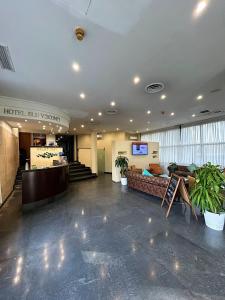a lobby of a hotel with a couch and a television at iH Hotels Milano Blu Visconti in Trezzano sul Naviglio