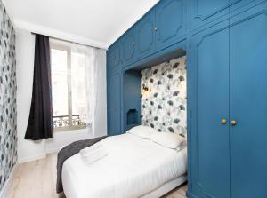 een blauwe slaapkamer met een wit bed en een raam bij Hypercentre - 1mn Monaco - Neuf in Beausoleil