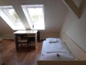 1 dormitorio con cama, escritorio y ventana en Martineum Felnőttképző Akadémia en Szombathely