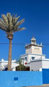 a palm tree in front of a lighthouse at Dar Yasmina in Sidi Ifni
