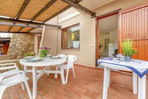 a dining room with white tables and white chairs at Moon Valley in Stintino