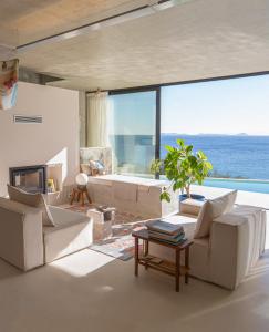 una sala de estar con muebles blancos y vistas al océano. en LASPI / PETRES, en Pefkali