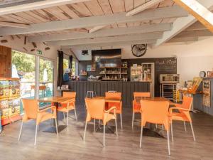 a restaurant with tables and chairs and a counter at Camping maeva Club Royal Océan in Saint-Sulpice-de-Royan