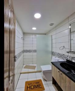 a bathroom with a toilet and a welcome sign on the floor at WADI Rum STARLIGHT CAMP in Wadi Rum