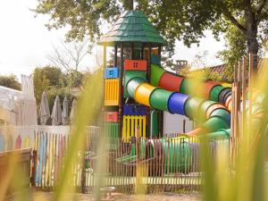 a playground with a colorful slide in a park at Camping maeva Club Royal Océan in Saint-Sulpice-de-Royan