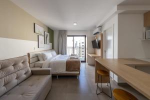 a hotel room with a bed and a couch and a desk at BHomy Bela Vista - Ap bem localizado ALFM4 in Sao Paulo
