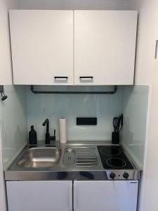a small kitchen with a sink and a stove at Studiowohnung 6 in Buxtehude in Buxtehude