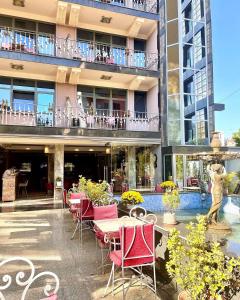 un patio con mesas y sillas frente a un edificio en Hotel Elysee, en Tirana