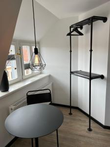 Zimmer mit einem Tisch, einem Stuhl und einer Lampe in der Unterkunft Studiowohnung 6 in Buxtehude in Buxtehude