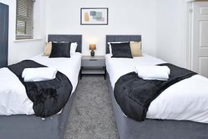 two twin beds in a room with white walls at The Pub - By Sigma Stays in Crewe