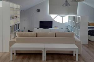 sala de estar con sofá blanco y TV en Salitre Málaga Center en Málaga