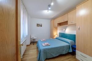 een kleine slaapkamer met een blauw bed en kasten bij Cinco de Copas in Zamora