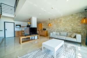 a living room with a white couch and a stone wall at Lures Hotel in Kalkan