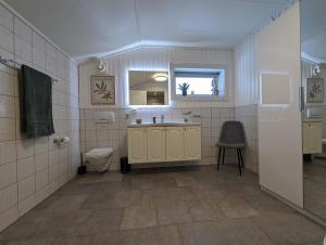 uma casa de banho com um lavatório, um WC e uma janela. em Sea & Mountain View Apartment Tromsø em Tromsø