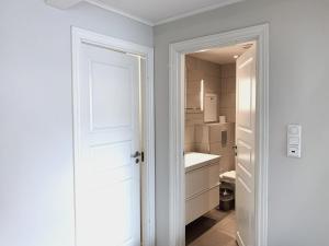 uma casa de banho branca com um lavatório e um WC em The Apartments Company - Bislett em Oslo