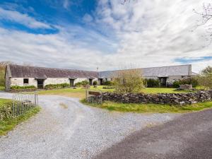 a farm with two barns and a stone wall at Ventry Farm - The Parlour Cottage in Ventry