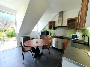 a kitchen with a wooden table and chairs in it at COCOONING TIME in Prenois