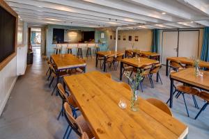 Nijhuizum的住宿－Groepsaccommodatie Fries en Fruitig Nijhuizum，用餐室配有木桌和椅子