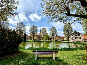 a park bench sitting in the grass near a pond at COCOONING TIME in Prenois