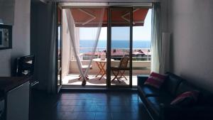 Una sala de estar con un sofá y vista al mar. en High in the Sky Apartments, en Sozopol