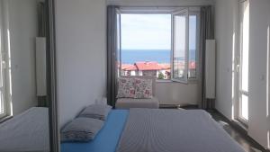 Un dormitorio con dos camas y una gran ventana. en High in the Sky Apartments, en Sozopol 20 fotos más