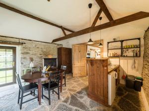 a kitchen and dining room with a wooden table at Ventry Farm - Rainbow Cottage in Ventry