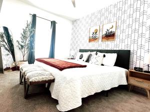 ein Schlafzimmer mit einem großen Bett mit weißer Bettwäsche und Kissen in der Unterkunft Boho Chic Luxury Retreat 5 Min to Parks & Food in Orlando