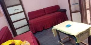 sala de estar con sofá rojo y mesa en الشاكر للايجار, en Menia