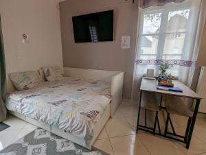 - une petite chambre avec un lit et une table dans l'établissement Marvellous Disney Home 7 min from Disneyland, à Magny-le-Hongre