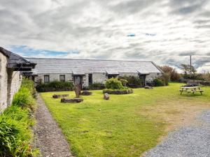 a building with a picnic table in a yard at Ventry Farm - Seaside Cottage in Ventry