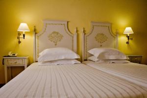 1 dormitorio con 2 camas y almohadas blancas en SL Hotel Santa Luzia – Elvas, en Elvas