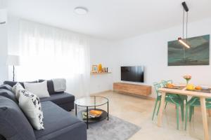 sala de estar con sofá y mesa en OceanVibe Loft MalagaFlat, en Málaga