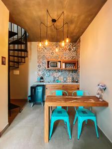 uma sala de jantar com uma mesa de madeira e cadeiras azuis em Chalés Belo Vale - Tiradentes em Tiradentes