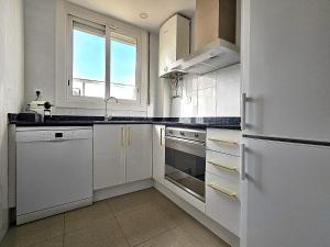 cocina blanca con electrodomésticos blancos y ventana en Classbedroom Fira Business Apartment, en Barcelona