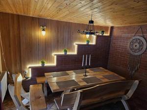 ein Esszimmer mit einem Holztisch und einer Ziegelwand in der Unterkunft Svirnelis in Medsėdžių