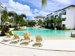 una piscina con tumbonas y un complejo en Beautiful Star of the Caribbean - Apartment Estrella Dominicus Bayahibe, en La Laguna